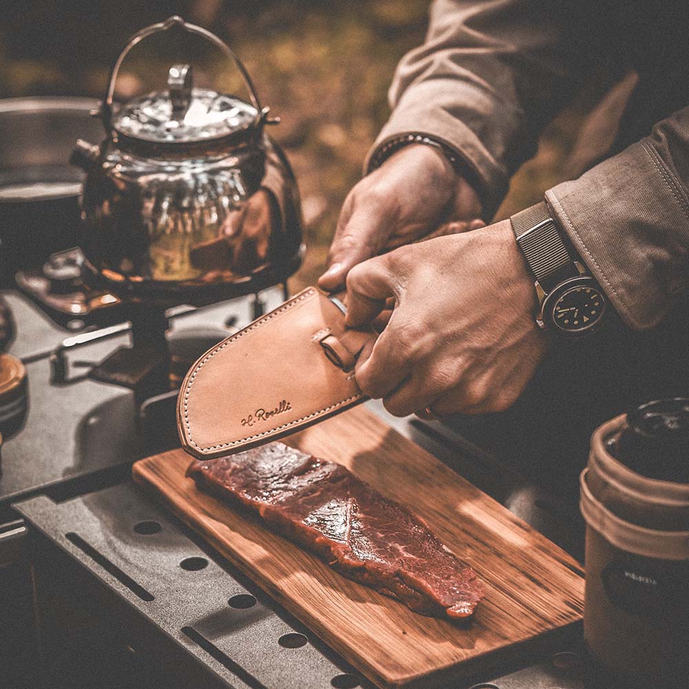 Roselli's handmade Finnish kitchen knife for chefs in carbon steel and a handle made from curly birch. Delivers with a handmade leather sheath. Perfect for both the outdoor and indoor kitchen..